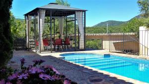 a gazebo with a table and chairs next to a pool at Casa de lujo en el Parque Nacional de Cabañeros in Navas de Estena