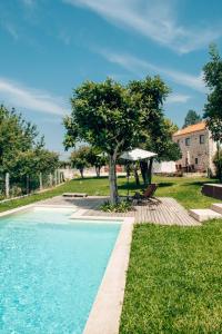 a swimming pool in a yard with a tree at Just Like Home - Holly House em Cerveira in Reboreda