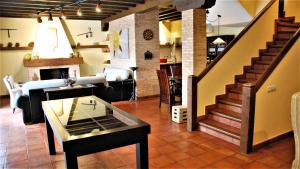 a living room with a staircase and a living room with a table at Casa de vacaciones en Parque Nacional de Cabañeros in Navas de Estena