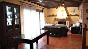 a living room with a table and a couch and a fireplace at Casa de vacaciones en Parque Nacional de Cabañeros in Navas de Estena