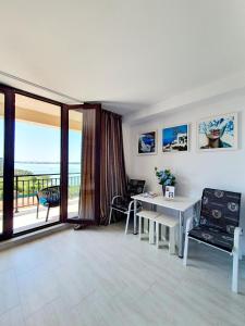 a living room with a table and a balcony at Coral Residence -Mamaia Nord in Mamaia
