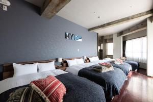 2 Betten in einem Schlafzimmer mit blauen Wänden in der Unterkunft Volcano in Kagoshima