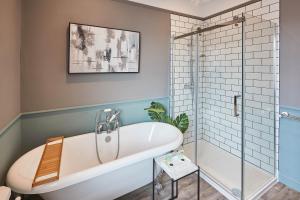 a bathroom with a tub and a glass shower at Host & Stay - The Railman's House in York