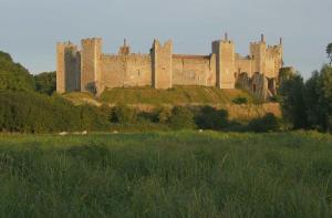 a castle on top of a hill with a field at Self-contained, Framlingham Snug, Private Parking, no cooking facilities in Framlingham