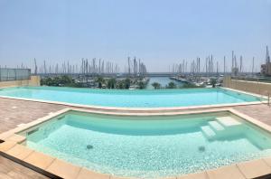 een groot zwembad met uitzicht op een jachthaven bij Aregai Marina Exclusive Seaside Apartments in Santo Stefano al Mare