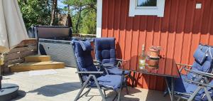 - un patio avec deux chaises et une table dans l'établissement möja stuga i Stockholms skärgård, à Stockholm