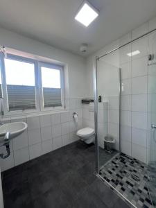ein Bad mit einem WC, einem Waschbecken und einer Dusche in der Unterkunft Motel am Outletcenter in Neumünster