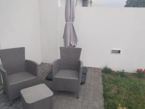 un patio con due sedie, un tavolo e un ombrellone di Brava a Vila Franca do Campo