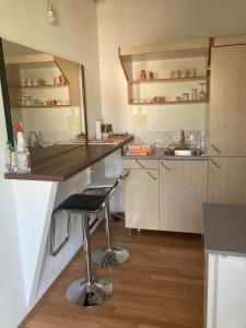 a small kitchen with a counter and a bar stool at Apartman "Kruna" in Belgrade