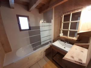 a bathroom with a tub and a sink and a bath tub at Maison de montagne dans charmant village du Capcir in Fontrabiouse