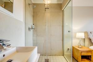 ケープタウンにあるQuayside Canal Eden Homeのシャワー、浴槽、洗面台を備えたバスルーム