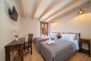 a bedroom with two beds and a desk and a television at Panorama View Villas - Villa Ostria and Levante in Fokáta +36 photos