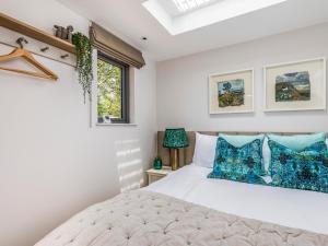 a bedroom with a white bed with blue pillows at Pass the Keys Peaceful And Beautiful Barn In Downland Village in Chichester