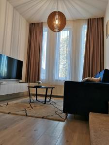 a living room with a tv and a couch and a table at Studio apartment INDIGO in Osijek