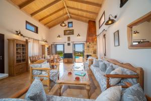 a living room with couches and a table at Panorama View Villas - Ostria Villa in Fokáta