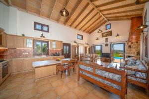 a large kitchen with a table and a couch at Panorama View Villas - Ostria Villa in Fokáta