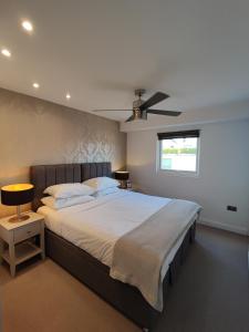 a bedroom with a large bed with a ceiling fan at Modern 2 Bedroom Flat with private outdoor terrace in London