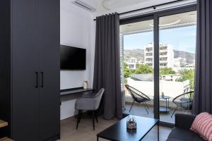 a living room with a desk and a large window at Nerea Boutique Suites Karystos in Karistos