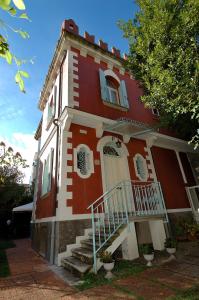 una casa rossa e bianca con le scale davanti di Villa Angelica a Lido di Venezia