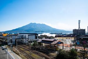 a view of a train station with a mountain in the background at Volcano in Kagoshima
