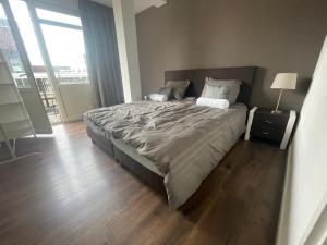1 dormitorio con 1 cama grande y suelo de madera en TopSleep Apartment 26-1, en Arnhem