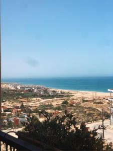 un apartamento en condominio con vistas a la playa desde el balcón en Manzili Surfhouse en Tamraght Ouzdar