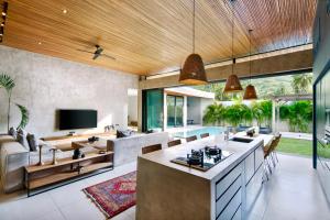 an open kitchen and living room with a couch and a television at Kabila Villas in Kuta Lombok