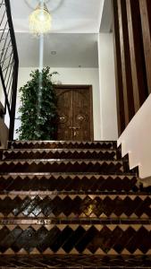 a large wooden door in a room with stairs at Manzili Surfhouse in Tamraght Ouzdar