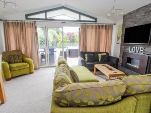 Honeysuckle Lodge في أبرجيل: غرفة معيشة مع أريكة ومدفأة