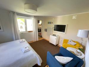 ein Schlafzimmer mit einem Bett, 2 Stühlen und einem TV in der Unterkunft Villa Kulle in Virserum