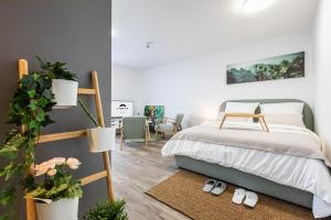 a bedroom with a bed and a ladder and plants at Modern Studio good located Balcony King Bed in Frankfurt