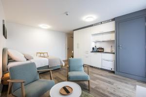 a bedroom with a bed and two chairs and a kitchen at Modern Studio good located Balcony King Bed in Frankfurt