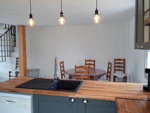 a kitchen with a sink and a table with chairs at Maison landaise rénovée avec charme in Lit-et-Mixe