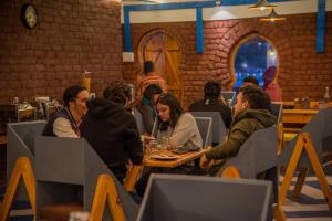 een groep mensen aan een tafel in een restaurant bij Black Sheep Bed & Breakfast in Kargil