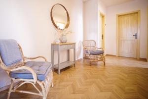 a room with two chairs and a mirror on the wall at Magtár Villa in Bóly