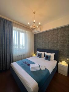 a bedroom with a large bed with towels on it at Yerevan4you Ararat View in Yerevan