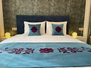 ein Bett mit einer blauen Decke und Kissen darauf in der Unterkunft Yerevan4you Ararat View in Yerevan