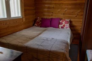 a bed in a room with wooden walls at Luxury Villa Rahavaara in Joensuu