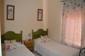 a bedroom with two beds and a table with a window at Villa Dulce Algarve Golf and Beach in Islantilla