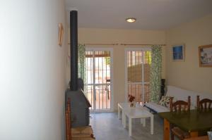 ein Wohnzimmer mit einem Holzofen und einem Tisch in der Unterkunft Villa Dulce Algarve Golf and Beach in Islantilla