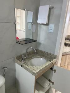 a bathroom with a sink and a mirror at Flats Sol e Mar in São José da Coroa Grande +37 photos