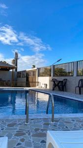 a swimming pool in a yard with chairs and a building at Flats Sol e Mar in São José da Coroa Grande