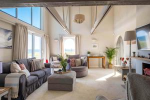 a living room with couches and a large window at Needles Point in Milford on Sea