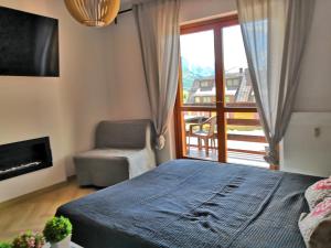 a bedroom with a bed and a view of a balcony at Ski&Bike Apartment Passo Tonale in Ponte di Legno