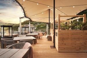 an outdoor restaurant with tables and chairs and lights at The Old Success Inn in Sennen Cove