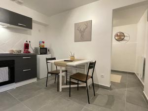 a kitchen with a table and chairs in a room at Grand studio tout équipé proche Paris & Disneyland in Ozoir-la-Ferrière