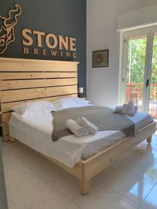 a bed in a bedroom with a sign on the wall at B&B&Beer in Cassano delle Murge