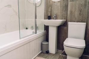 a bathroom with a toilet and a sink and a shower at Lovely one bedroom apartment COLCHESTER in Mile End