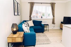 um sofá azul numa sala de estar com uma mesa em Lovely one bedroom apartment COLCHESTER em Mile End