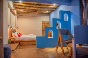 a room with a blue wall with a bed in the background at Black Sheep Bed & Breakfast in Kargil